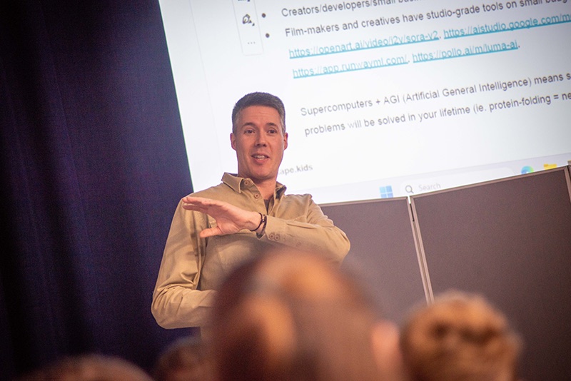 Stuart speaking to a class in front of a slide about AI